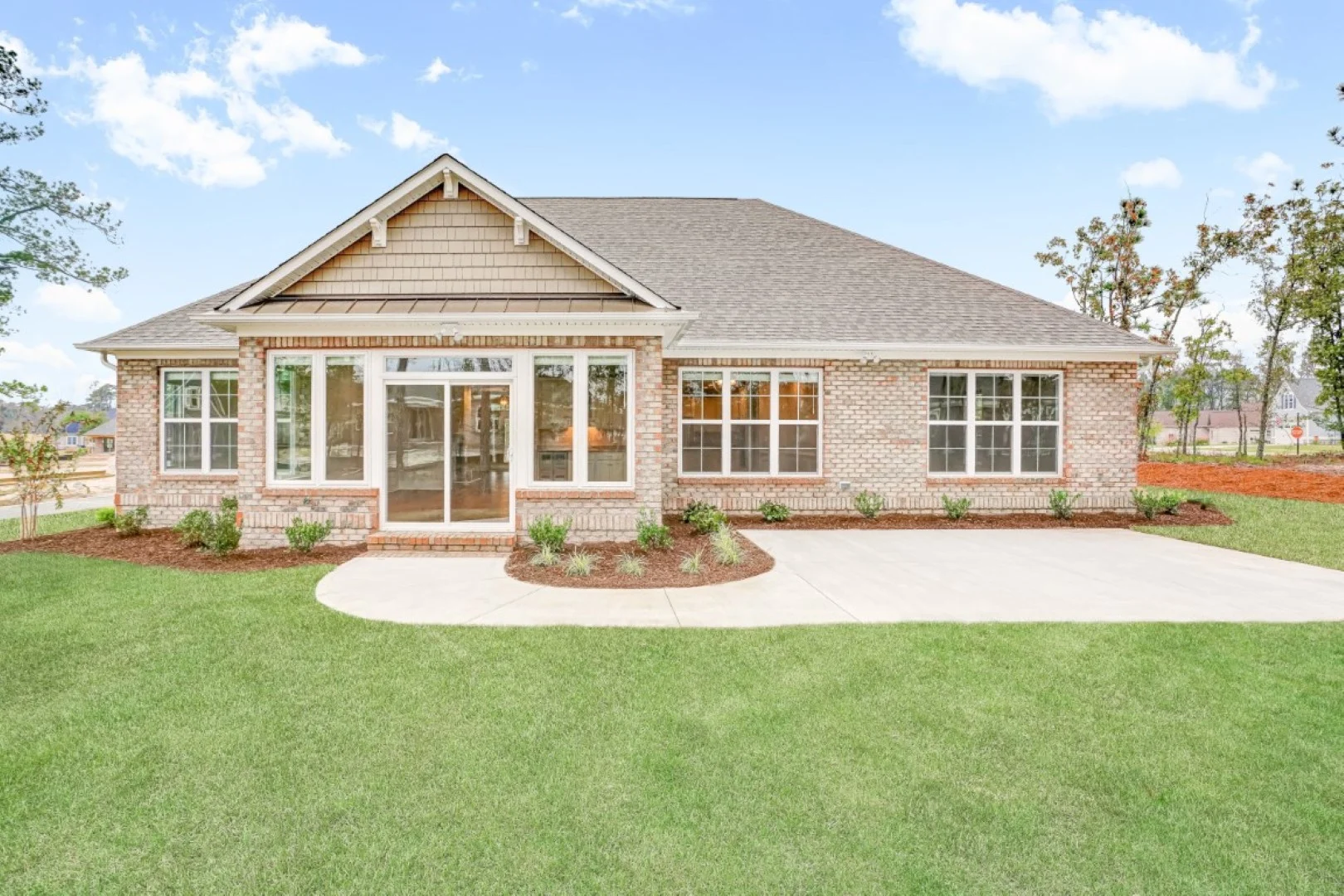 Single-story brick house with large windows and a well-maintained lawn, showcasing the craftsmanship of a skilled home builder.